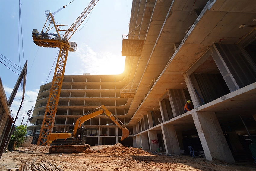 Construction site with crane and excavator building a concrete structure — industrial photography and branding visuals.