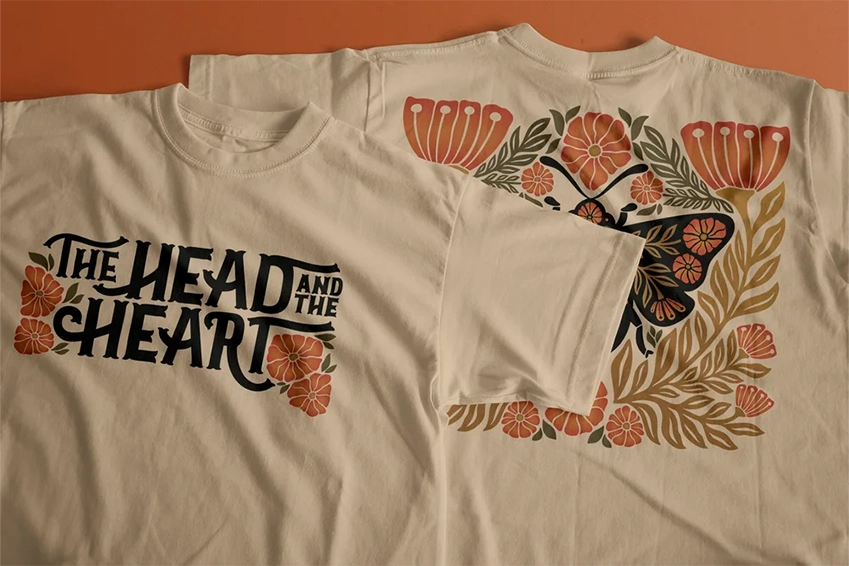 Cream-colored graphic T-shirts with floral and butterfly illustrations, featuring “The Head and the Heart” typography design on the front.
