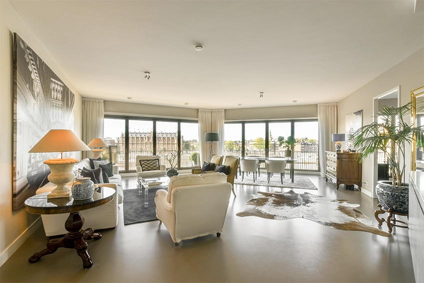 Bright modern living room with large windows, elegant furniture, and cityscape views in a luxury apartment.