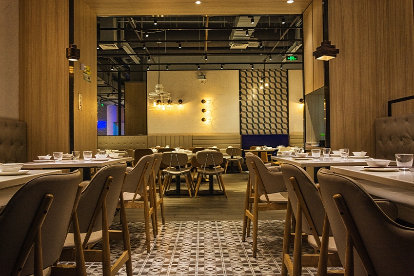 Modern restaurant interior with warm lighting and elegant table setup — hospitality design and branding photography.